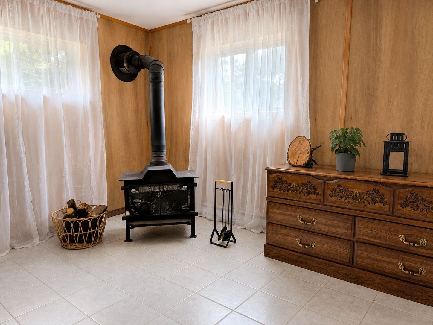 Wood stove in the basement with antique dresser and natural light