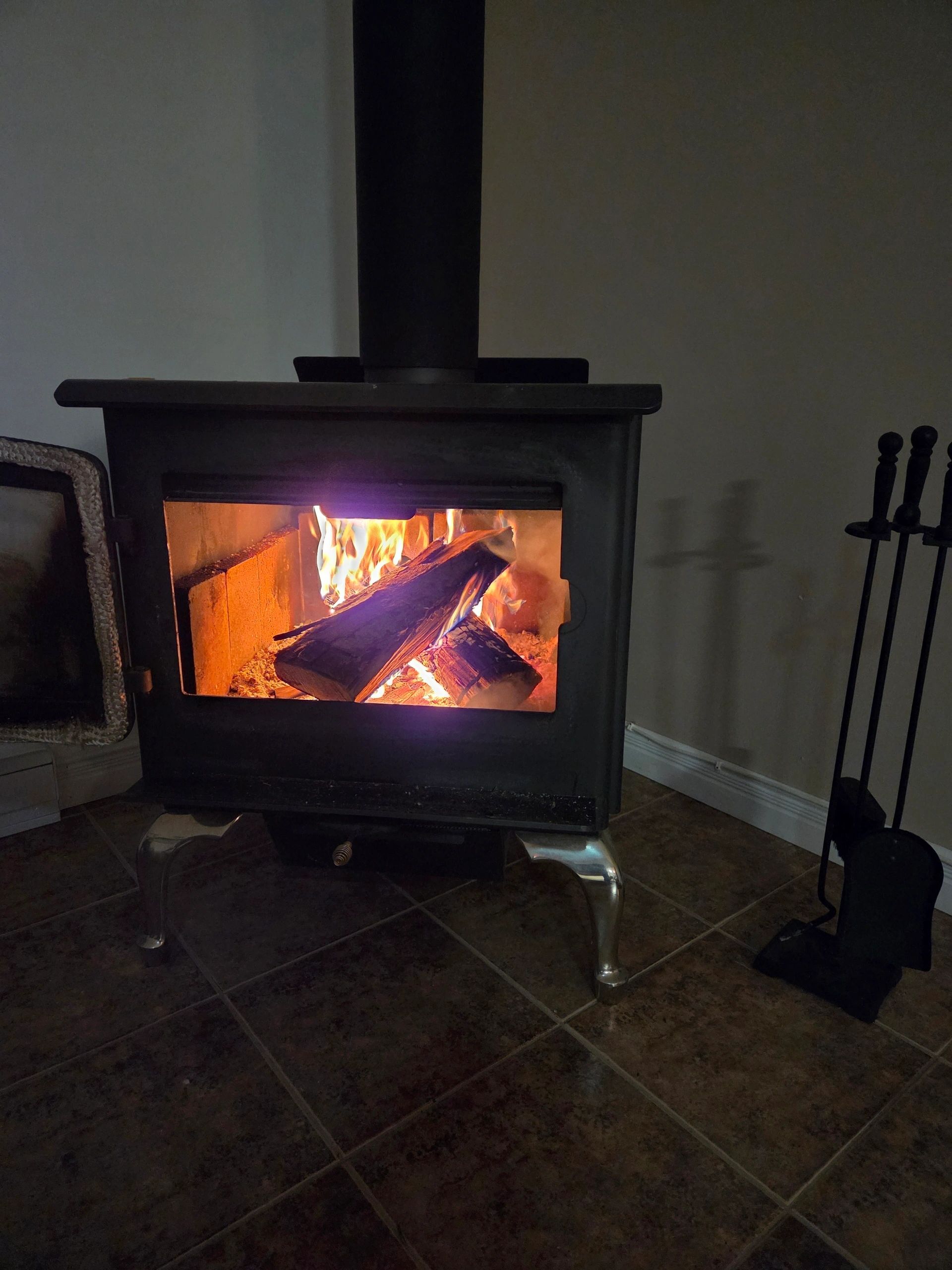 Wood-burning fireplace stove glowing with fire inside the chalet